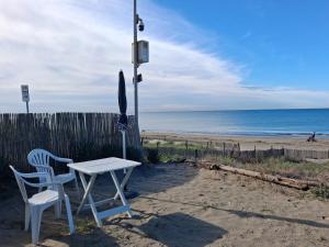 a table and two chairs sitting on the beach at CASINA SULLa SABBIA in Torvaianica +21 photos