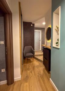 a room with a chair and a desk and a mirror at Celia Center Celje Apartment in Celje