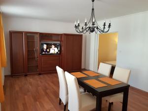 une salle à manger avec une table noire et des chaises blanches dans l'établissement Apartman Kaszás Central, à Mosonmagyaróvár