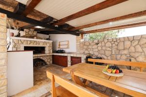 a kitchen with a wooden table and a stone wall at Anna in Drage