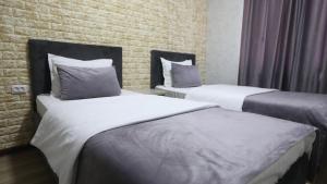 two beds in a hotel room with white sheets at Tashkent apart hotel in Tashkent