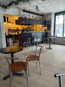 a restaurant with tables and chairs and a counter at Hôtel Du Mans in Angers