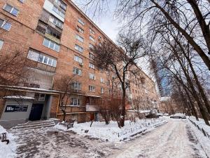 a snow covered street in front of a building at Kyiv Lesi 3 Studio Apartment in Kyiv