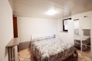 a small bedroom with a bed and a shelf at Ca' del Giuli in Maslianico