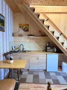 a kitchen with a sink and a staircase at KOMFORT in Berehove
