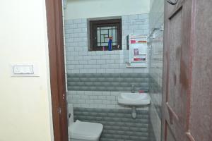 a bathroom with a sink and a toilet and a window at Nisarga Greens in Chittūr
