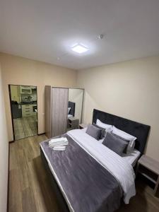 a bedroom with a large bed and a mirror at Tashkent apart hotel in Tashkent