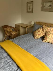 a bedroom with a bed with a yellow blanket on it at 18 Wixon Path in Buckinghamshire
