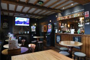 a bar with tables and chairs and a television at Sun Inn in Eastwood