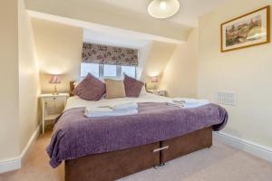 a bedroom with a large bed with purple sheets at 2 Bed in Wem oc-o30240 in Preesgreen