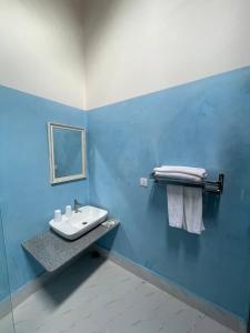 a bathroom with a sink and a blue wall at Villa Kep Sea & Mountains in Phumĭ Ŏng Char