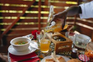 a person is pouring beer into a bowl of food at Banana Cottage Ecolodge & Spa in Le Gosier +10 photos