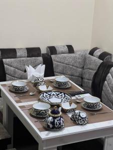 a table with plates and dishes on it with a couch at Tashkent apart hotel in Tashkent +14 photos