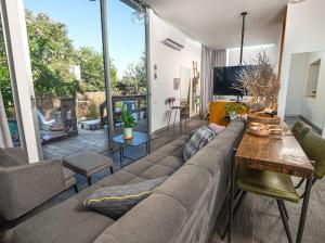 a living room with a large couch and a large window at Felina place by shuli in Ganne Yoẖanan