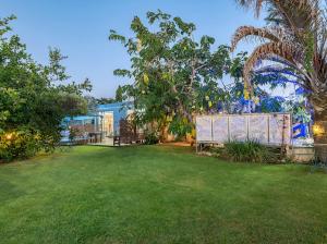 a yard with a fence and trees and a building at Felina place by shuli in Ganne Yoẖanan