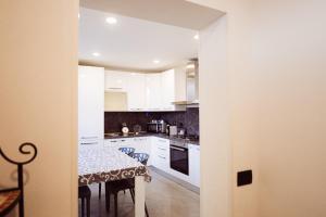a kitchen with white cabinets and a table with chairs at Residenza Caterina in Maslianico