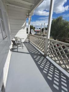 a porch with a bench and a chair on it at Her Home in Purranque