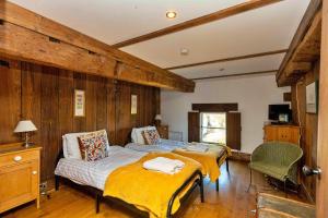 two beds in a room with wooden walls at Finest Retreats - Fletland Mill in Stamford