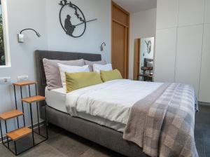 a bedroom with a large bed with two tables at Felina place by shuli in Ganne Yoẖanan +75 photos