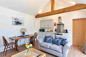 a living room with a couch and a table at Finest Retreats - The Sett in Stamford +6 photos