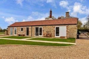 a brick house with a grass yard in front of it at Finest Retreats - The Sett in Stamford