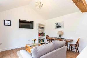 a living room with a couch and a table at Finest Retreats - The Sett in Stamford