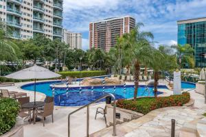 a swimming pool with tables and chairs and buildings at Pineapples BPremium - Excelentes suítes in Rio de Janeiro