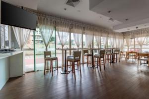 a dining room with tables and chairs and windows at Pineapples BPremium - Excelentes suítes in Rio de Janeiro