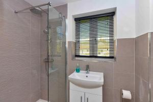 a bathroom with a sink and a glass shower at Finest Retreats - The Roost in Stamford +12 photos