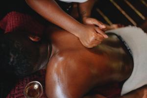 a woman getting a knee massage on her leg at Banana Cottage Ecolodge & Spa in Le Gosier
