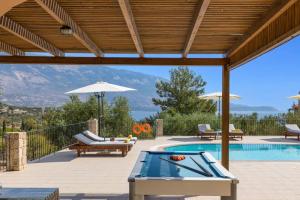 a patio with a swimming pool with a wooden pergola at Villa Sandy Cove by Villa Plus in Spartià
