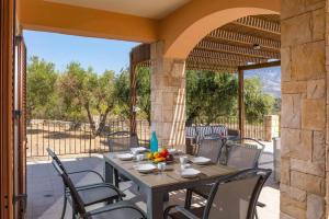 a patio with a table and chairs on a patio at Villa Sandy Cove by Villa Plus in Spartià