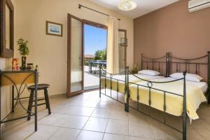 a bedroom with a bed and a balcony at Villa Sandy Cove by Villa Plus in Spartià
