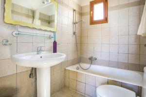 a bathroom with a sink and a toilet and a tub at Villa Sandy Cove by Villa Plus in Spartià +12 photos