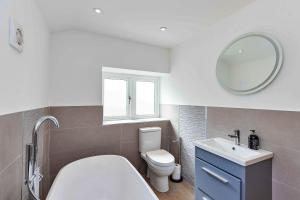 a bathroom with a toilet and a sink and a mirror at Finest Retreats - The Warren in Stamford +11 photos