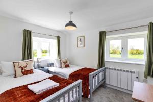 a bedroom with two beds and a window at Finest Retreats - The Warren in Stamford