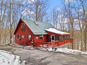 a red house with a green roof in the snow at Pet-Friendly w Fire Pit Grill & Resort Access in Hedgesville