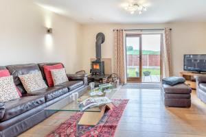 a living room with a leather couch and a fireplace at 4 Bed in Wonastow oc-k29425 in Wonastow