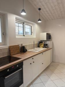 a kitchen with white cabinets and a counter top at BoomCoeur in Niort