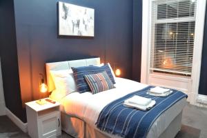 a bedroom with a bed with two towels on it at Manchester Ashton Suites in Ashton under Lyne