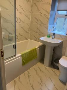 a bathroom with a sink and a tub and a toilet at 18 Wixon Path in Buckinghamshire +1 photo