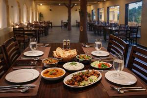 a wooden table with plates of food on it at Baghin Resort in Khilchipur +33 photos