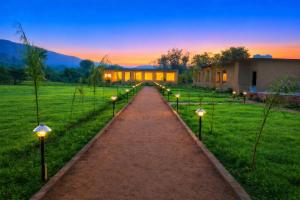 a pathway with lights in a field with a house at Baghin Resort in Khilchipur