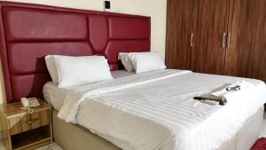 a bedroom with a large bed with a red headboard at GTKATE Paradise Hotel in Ikeja