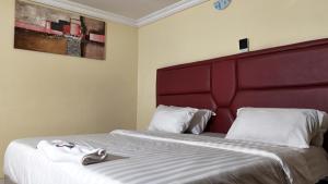 a hotel room with a bed with a red headboard at GTKATE Paradise Hotel in Ikeja