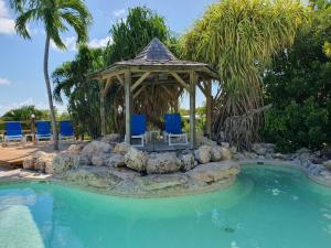 a gazebo and chairs in a swimming pool at Hostellerie des châteaux in Saint-François
