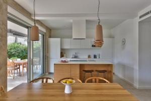 a kitchen and dining room with a wooden table and chairs at Jadrija Luxury Vacations Apt1 in Šibenik +42 photos
