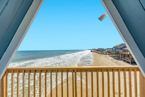a view of the beach from the balcony of a beach house at Iconic A Frame Sleep Over the Gulf in Surfside Beach