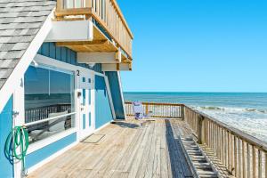 a house with a deck with the ocean at Iconic A Frame Sleep Over the Gulf in Surfside Beach +19 photos