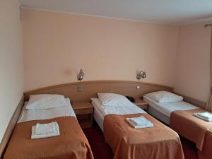 a hotel room with two beds with towels on them at Hotel Maggi in Rogoźno